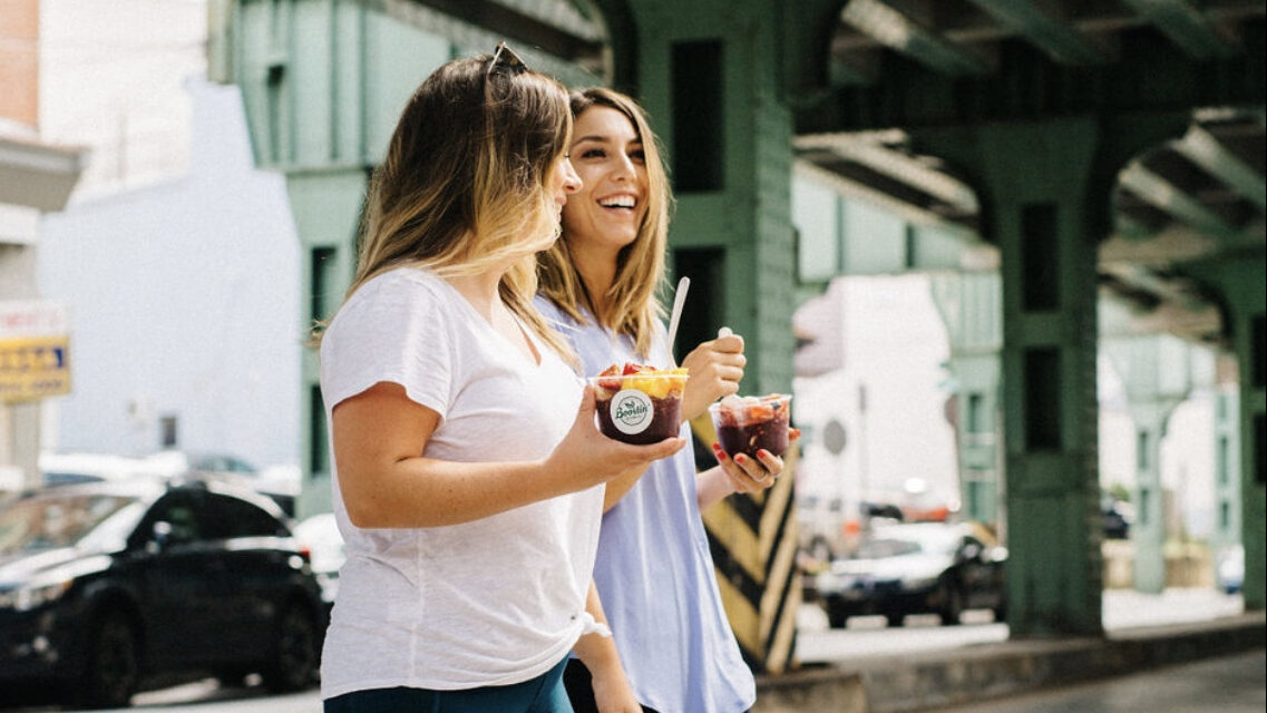 Two customers walking under the green Manayunk bridge