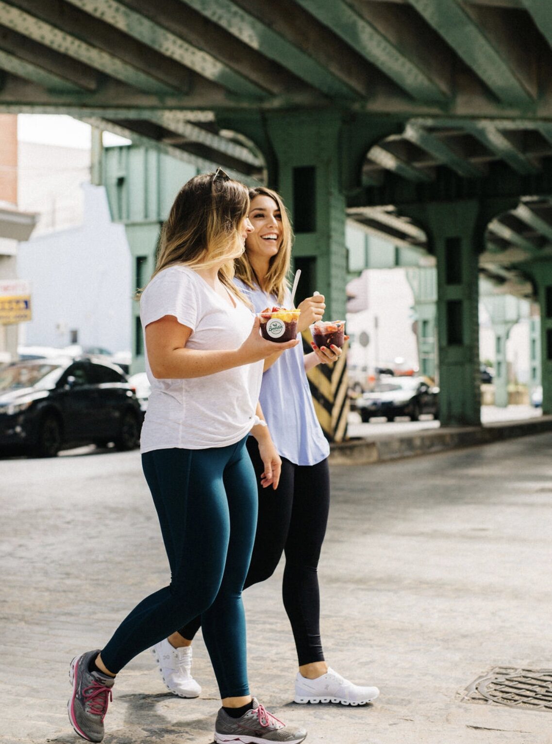 Two customers walking under the green Manayunk bridge