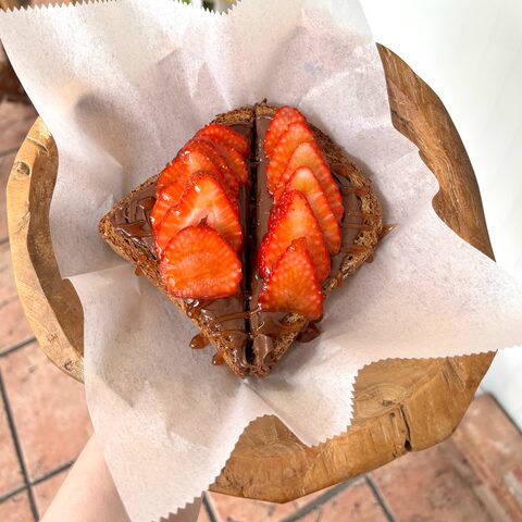Multigrain toast with Nutella, fresh strawberries, and cinnamon honey drizzle
