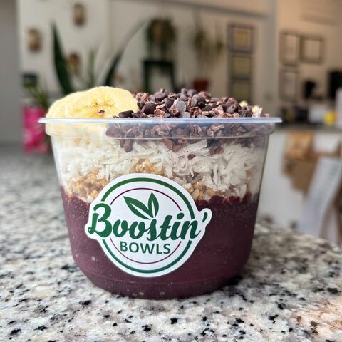 Purple bowl with granola, banana, chocolate chips, and cacao nibs