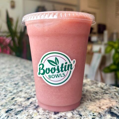 Pink smoothie with almond milk, banana, strawberries, and honey